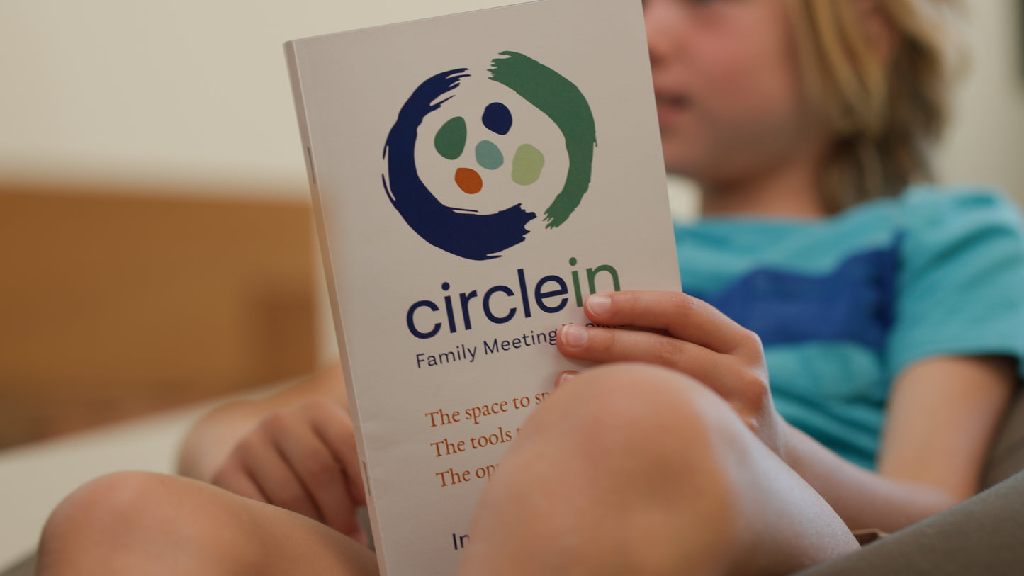 Young kid holding a Circle In family meeting toolkit instruction booklet