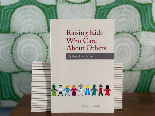 Stack of beige books titled 'Raising Kids Who Care About Others' by Betty Lou Bettner with a green patterned background