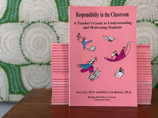A stack of pink books titled 'Responsibility in the Classroom' in front of a textured green and white background.