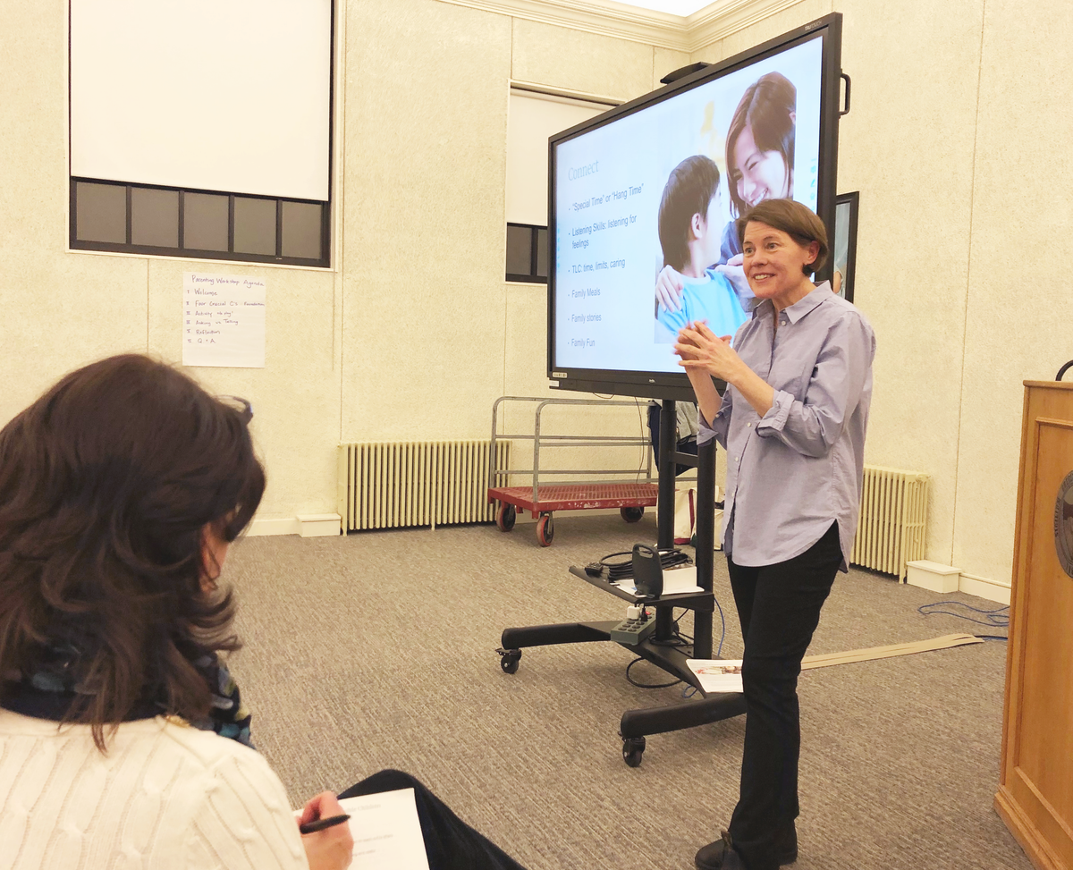 Marjie Longshore presenting in front of an audience by a large screen
