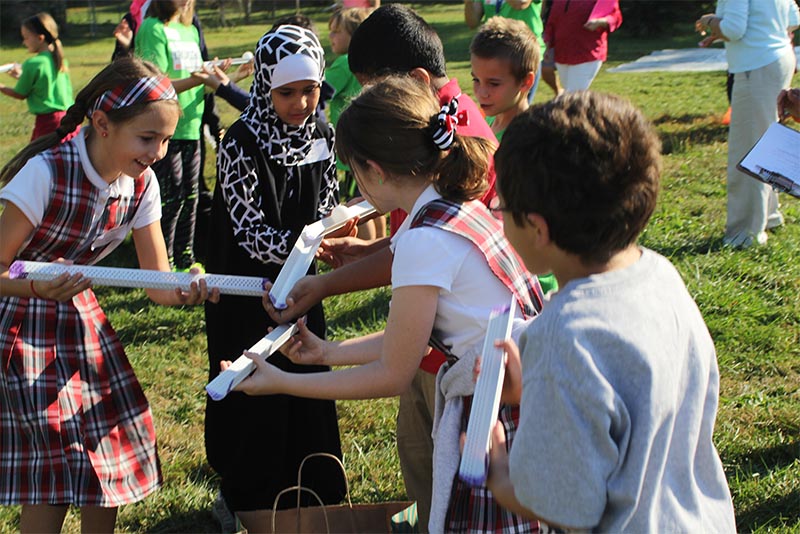 Children outside in field interacting with an educational toy